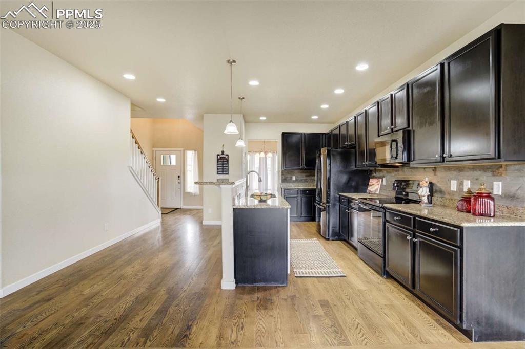 Image 12 of 50: Kitchen Overview – Spacious kitchen with dark cabinetry, granite countertop