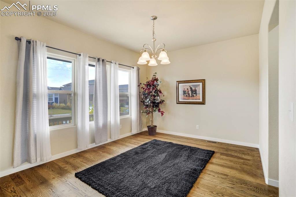 Image 18 of 50: Dining Room – Bright dining room with large windows, hardwood floors, and a