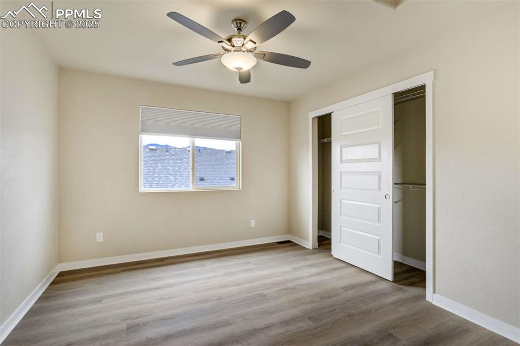 Image 31 of 50: Bedroom 2 – Bright secondary bedroom featuring updated flooring, large wind