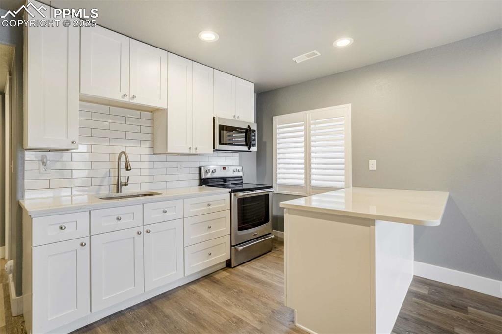 Image 41 of 50: Basement Kitchenette (Close-Up) – Crisp white cabinets, subway tile backspl