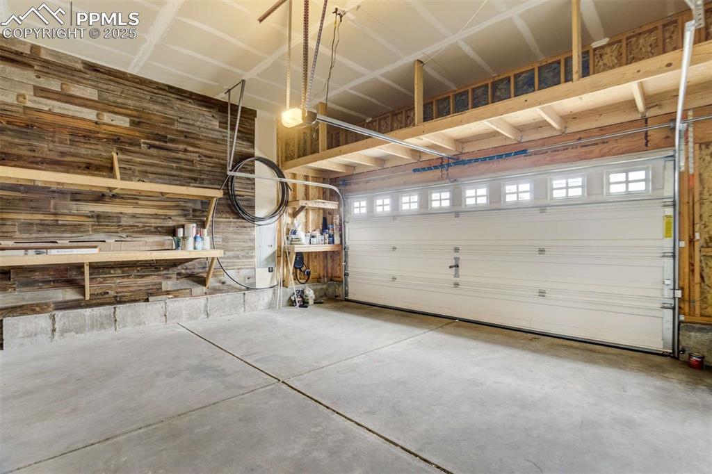 Image 46 of 50: Garage (Wide View) – Oversized 2-car garage featuring high ceilings, custom