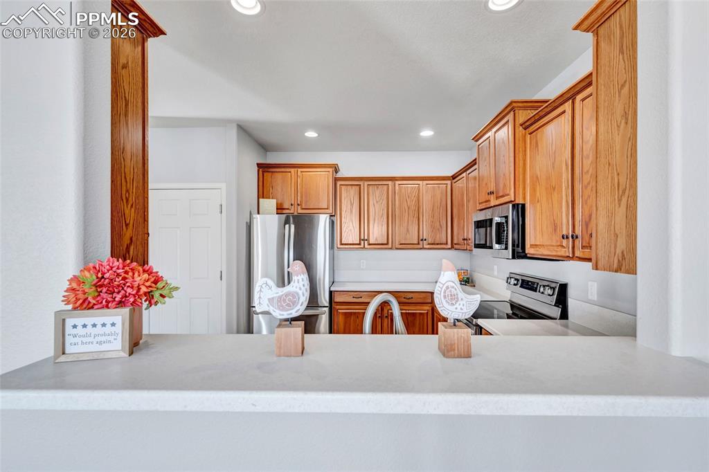 Image 12 of 38: Breakfast bar looking into kitchen