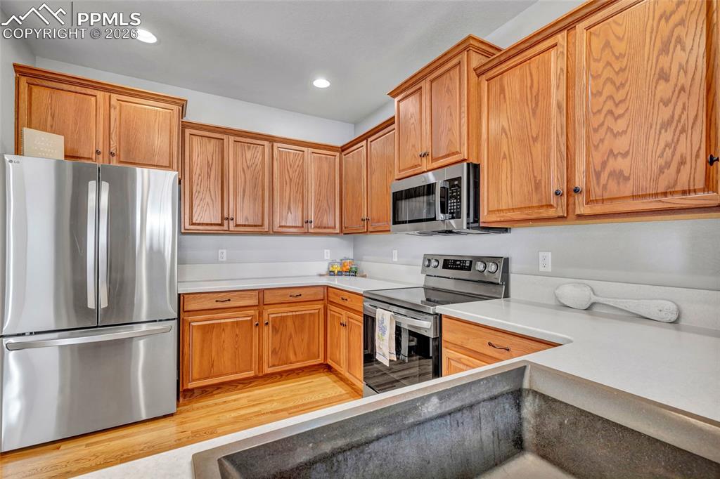 Image 13 of 38: Remodeled kitchen with Corian countertops, new sink, and stainless steel ap