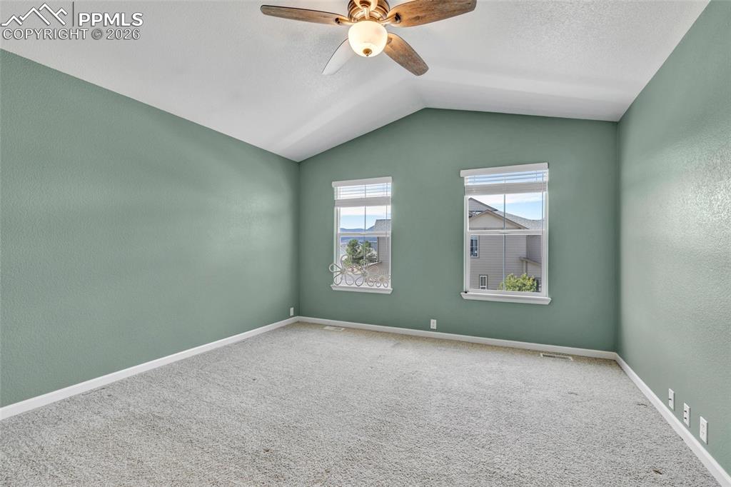 Image 22 of 38: Spacious primary with fresh paint, large windows, and walk-in closet