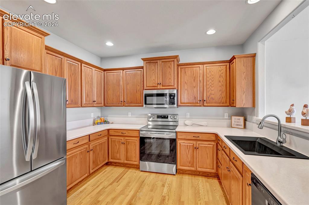 Image 5 of 42: Remodeled kitchen with Corian countertops, new sink, and stainless steel ap