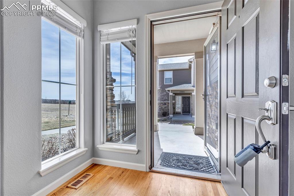 Image 8 of 38: Hardwood floors, floor to ceiling windows with new window coverings
