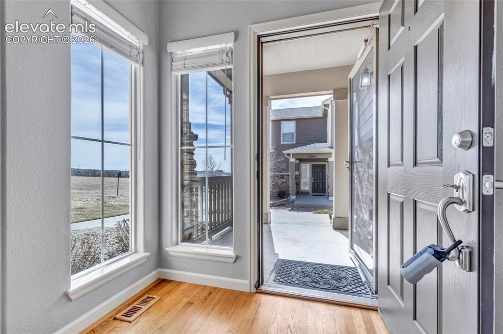 Image 9 of 42: Hardwood floors, floor to ceiling windows with new window coverings