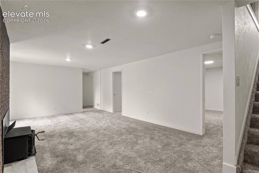 Image 19 of 30: Spacious carpeted room featuring white walls, recessed lighting, a built-in