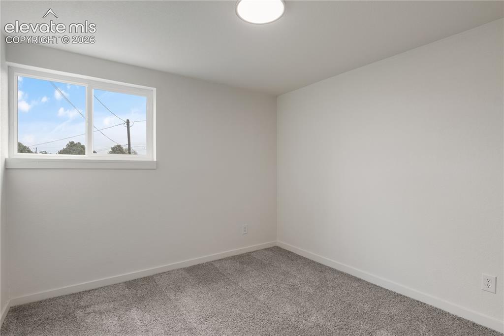 Image 23 of 30: Bright room featuring neutral-toned walls, gray-toned carpet flooring, a si