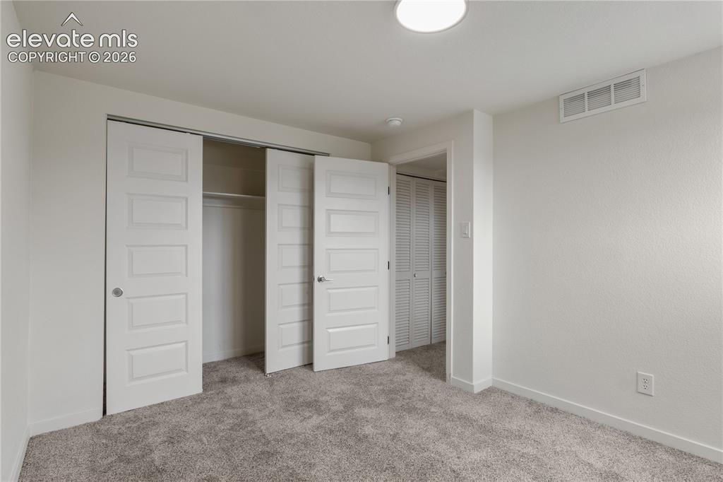 Image 24 of 30: Spacious room featuring plush carpet flooring, a contemporary ceiling light
