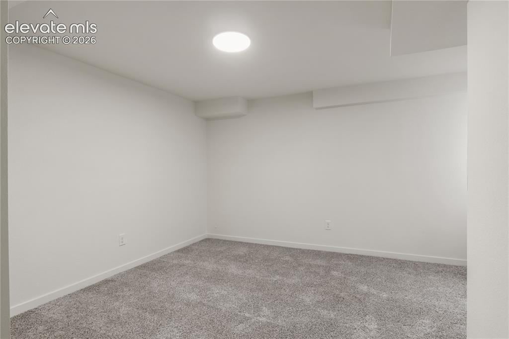 Image 25 of 30: Carpeted interior room with white walls, a circular ceiling light fixture, 