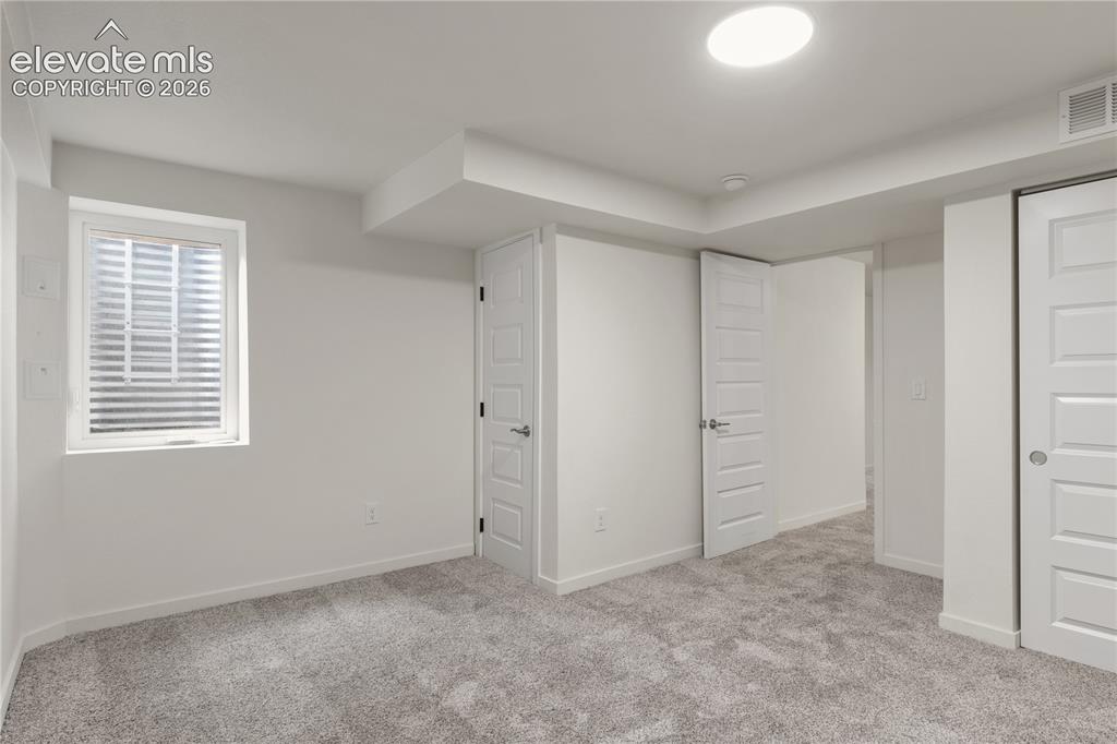Image 26 of 30: Spacious room featuring neutral carpeting, a large egress window, recessed 
