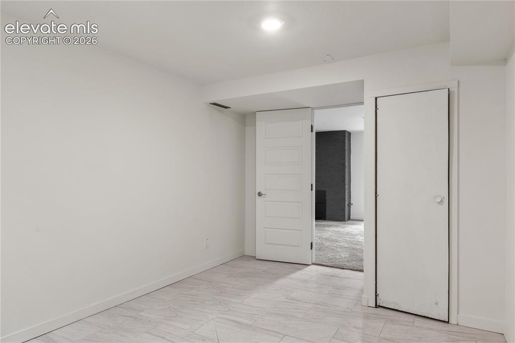 Image 28 of 30: Neutral-toned room with light-colored tile flooring