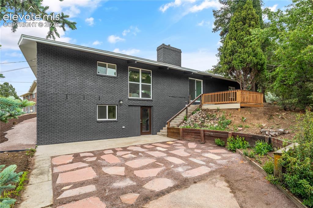 Image 29 of 30: Contemporary exterior featuring dark brick siding and a large picture windo
