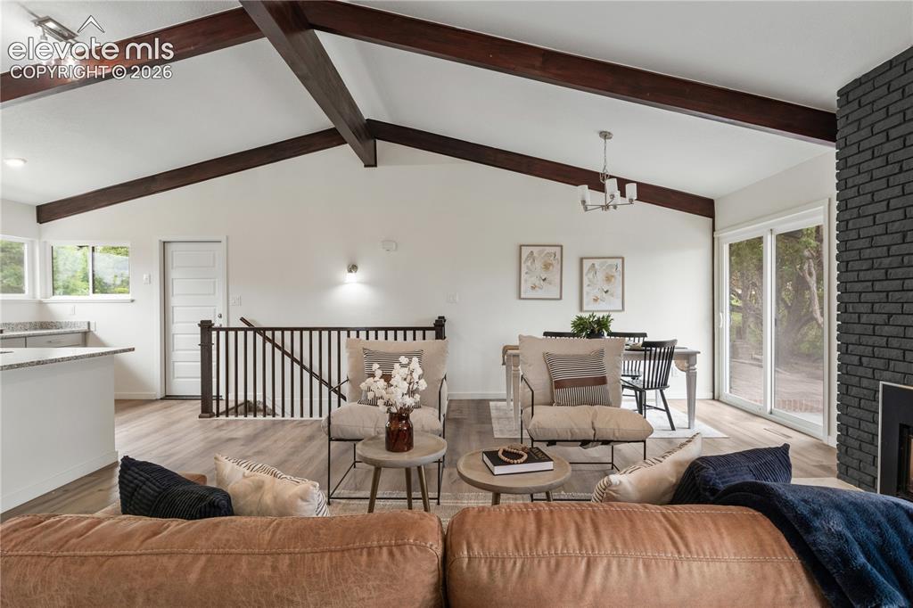 Image 6 of 30: Spacious open-concept living area featuring vaulted ceilings with exposed w