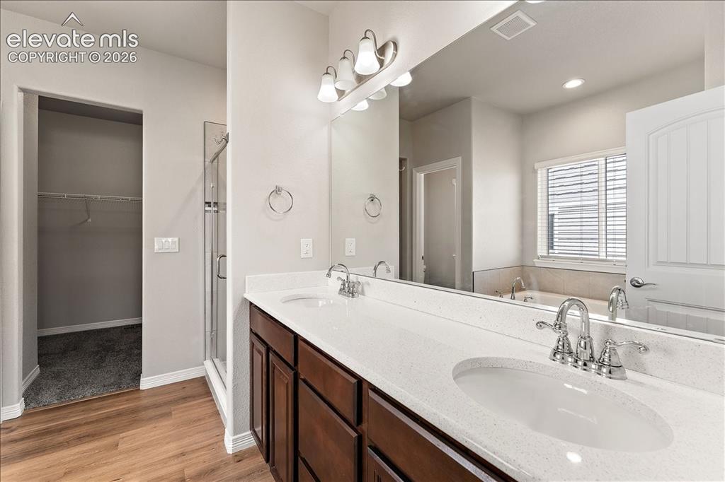 Image 11 of 48: Main level Primary bedroom five-piece bathroom and large room-size closet