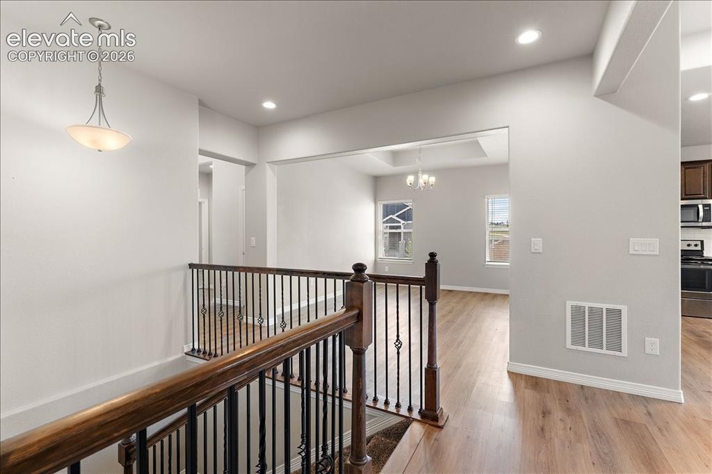 Image 16 of 48: Main level staircase to the large lower level across from the formal dining