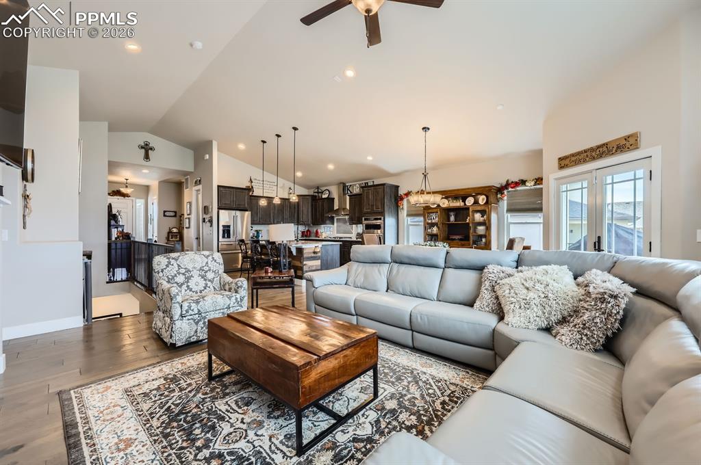 Image 5 of 27: Living area featuring lofted ceiling, ceiling fan, wood finished floors, an