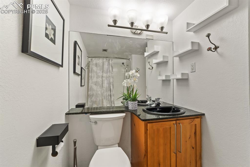 Image 16 of 32: Full bath featuring toilet, a shower with shower curtain, and vanity