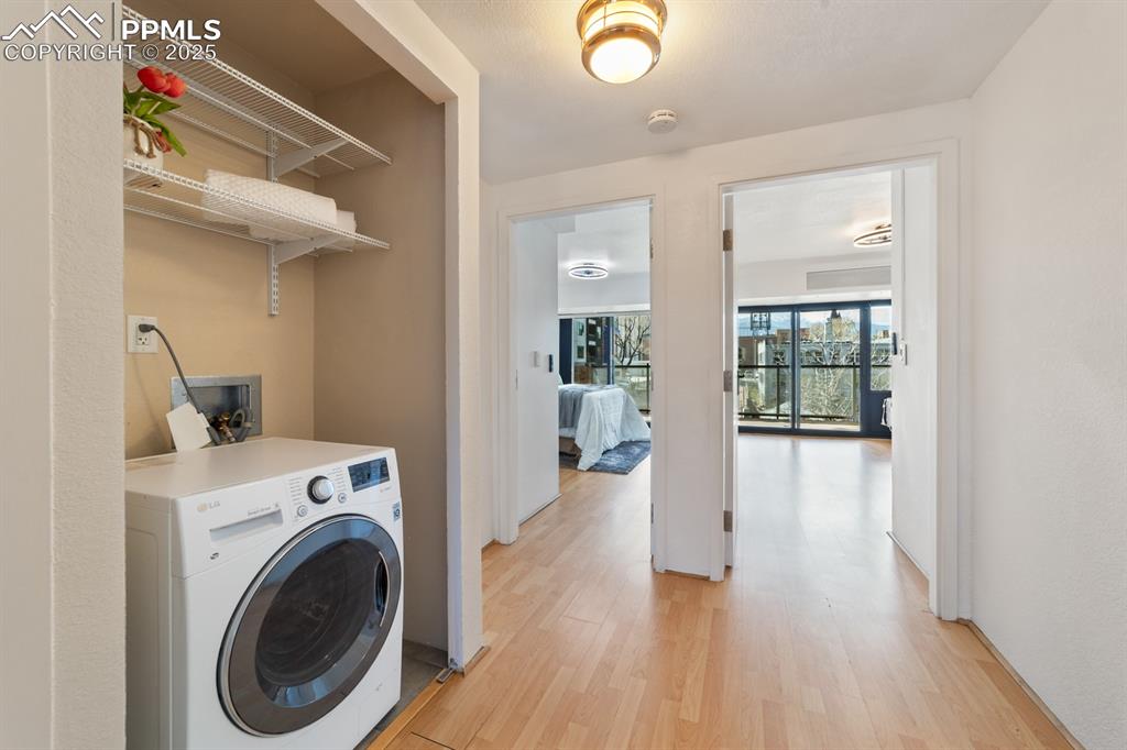 Image 19 of 32: Laundry room with washer / dryer and light wood-style flooring