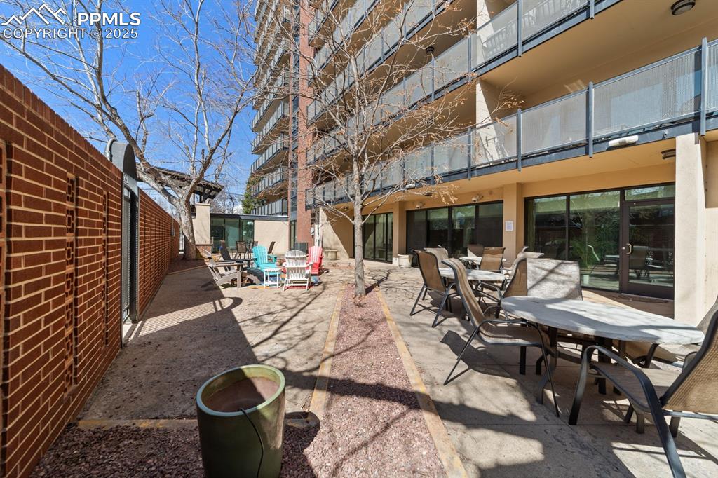 Image 22 of 32: View of patio featuring outdoor dining area and a balcony