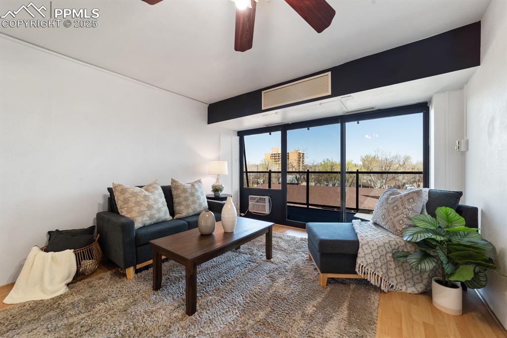 Image 6 of 32: Living room with wood finished floors and ceiling fan