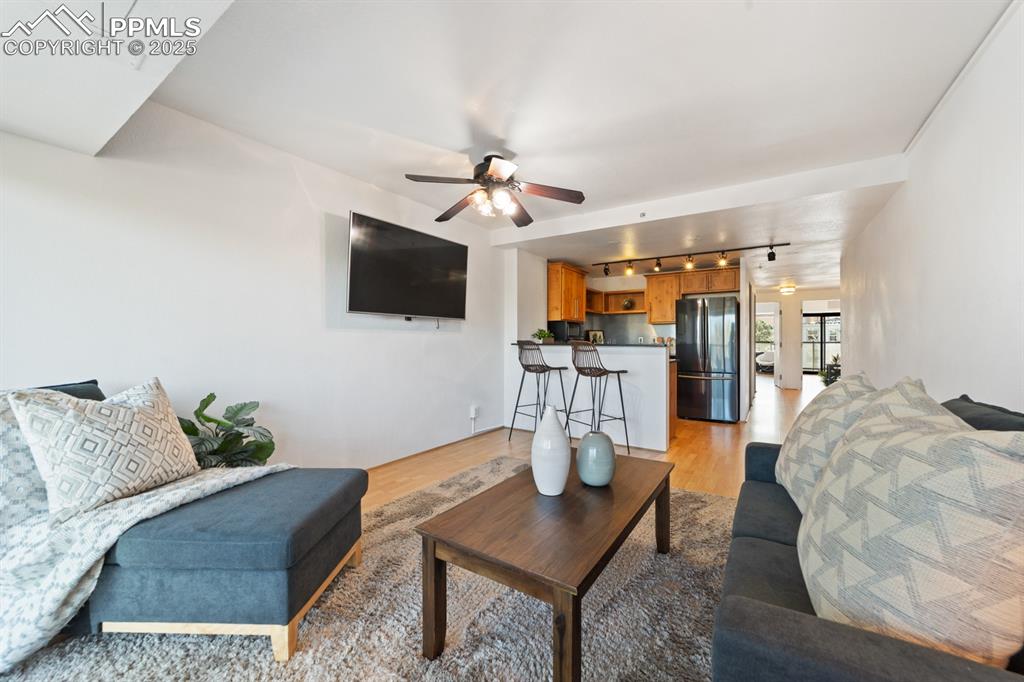 Image 7 of 32: Living room with rail lighting, light wood-type flooring, and a ceiling fan