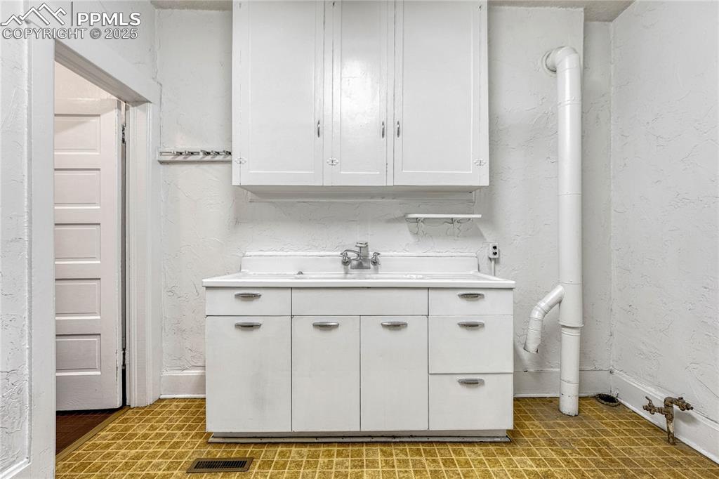 Image 17 of 48: Kitchen featuring sink and white cabinets