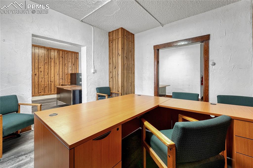 Image 21 of 48: Home office with light hardwood / wood-style flooring and a textured ceilin