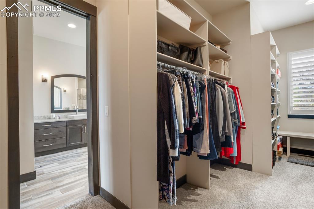 Image 15 of 31: Large walk-in primary closet with organization system.