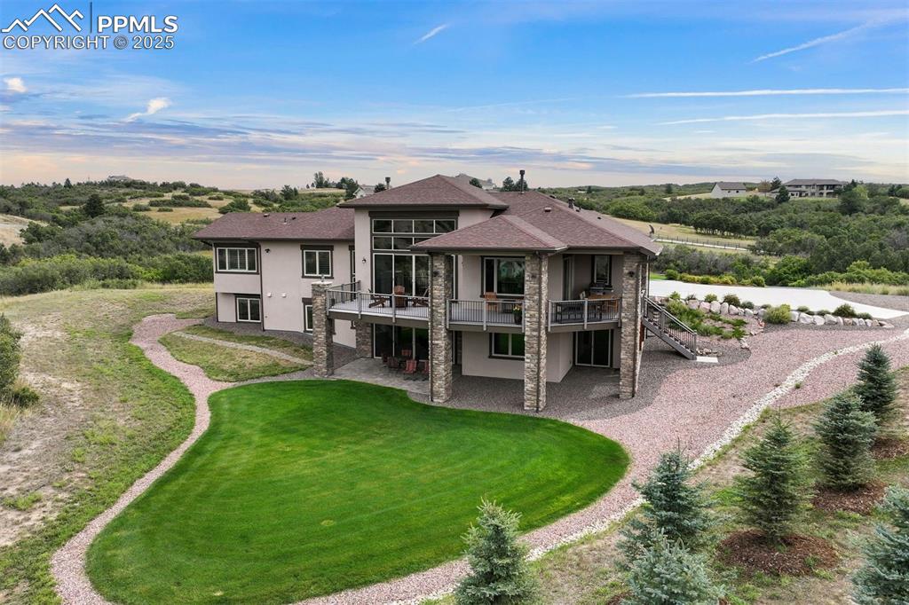 Image 28 of 31: Rear overview with large grassy lawn.