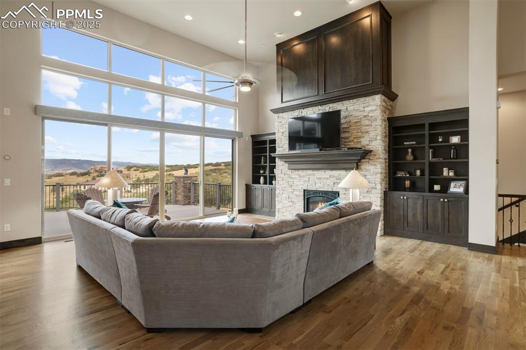 Image 5 of 31: Gas fireplace with stone surround, knotty alder floating mantle, wood accen