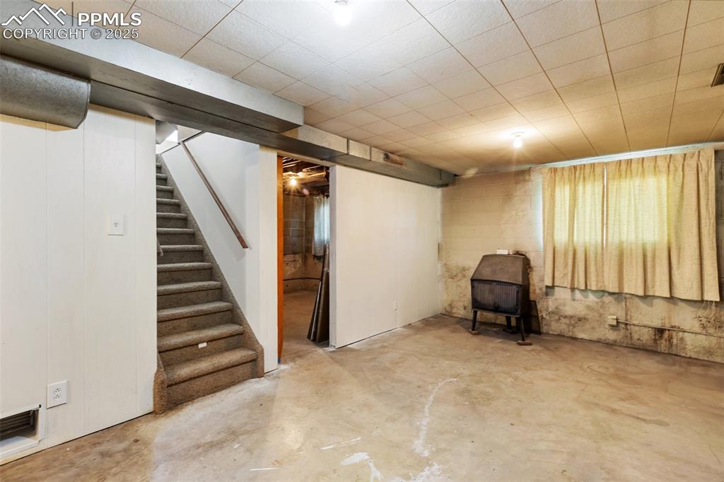 Image 23 of 36: Basement with woodburning stove!