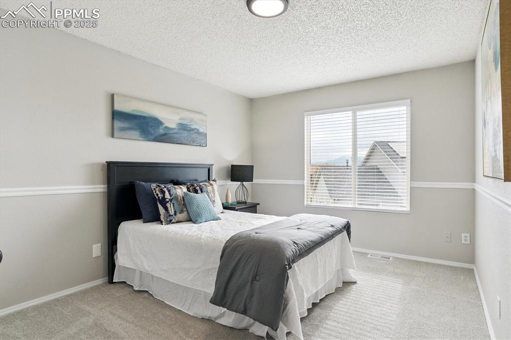 Image 16 of 40: Bedroom with carpet floors and a textured ceiling