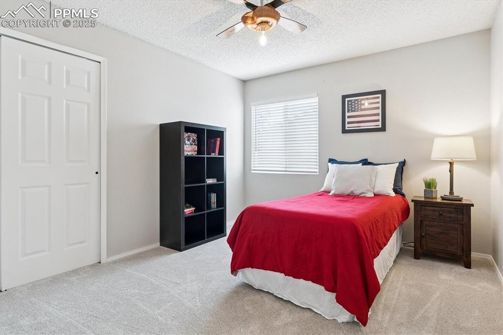 Image 19 of 40: Bedroom with light carpet, a textured ceiling, and ceiling fan