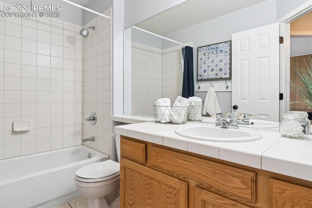 Image 23 of 40: Full bath with shower / tub combo, vanity, and tile patterned flooring