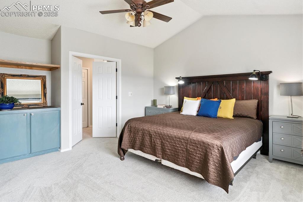 Image 26 of 40: Bedroom featuring light carpet, lofted ceiling, and ceiling fan
