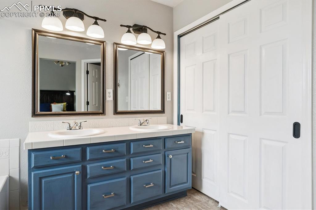 Image 27 of 40: Full bathroom featuring double vanity and a bathtub