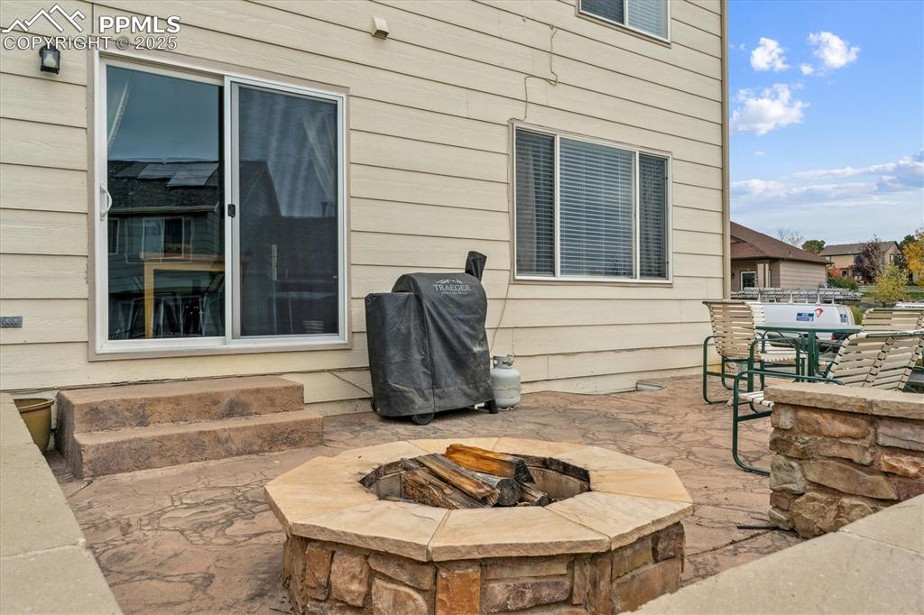 Image 38 of 40: View of patio featuring an outdoor fire pit and a grill