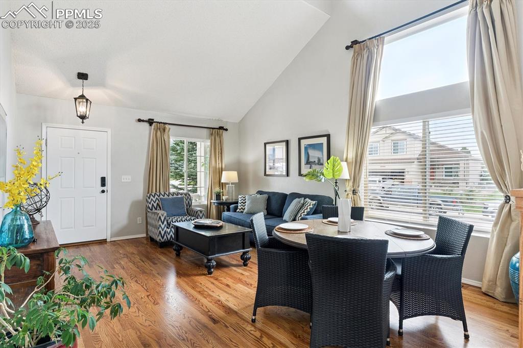 Image 4 of 40: Dining space featuring wood finished floors and high vaulted ceiling