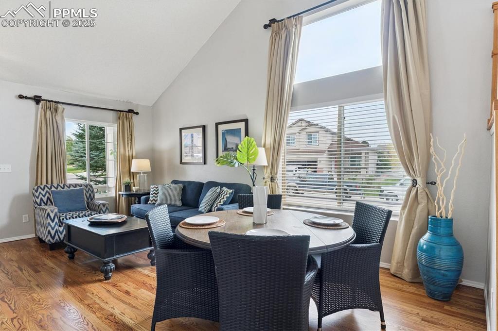 Image 7 of 40: Dining area featuring light wood-type flooring and high vaulted ceiling