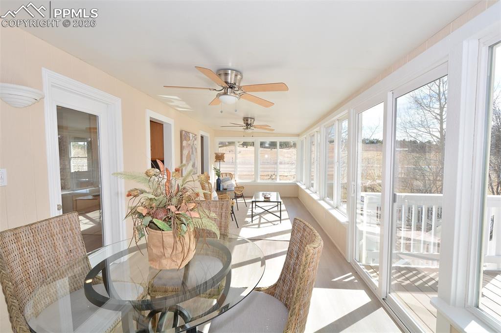 Image 14 of 50: Bright and inviting sunroom with room for a table and sitting area overlook