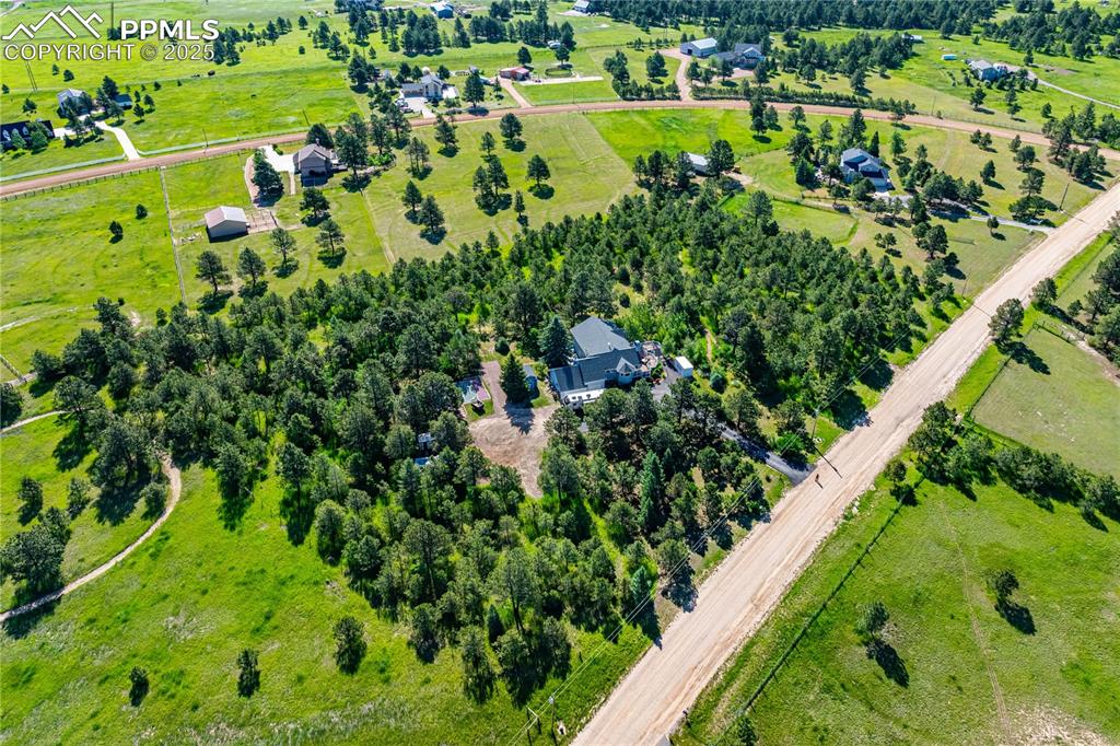 Image 3 of 33: Ariel view of 5 acres of beautifully landscaped lot. Variety of trees and s