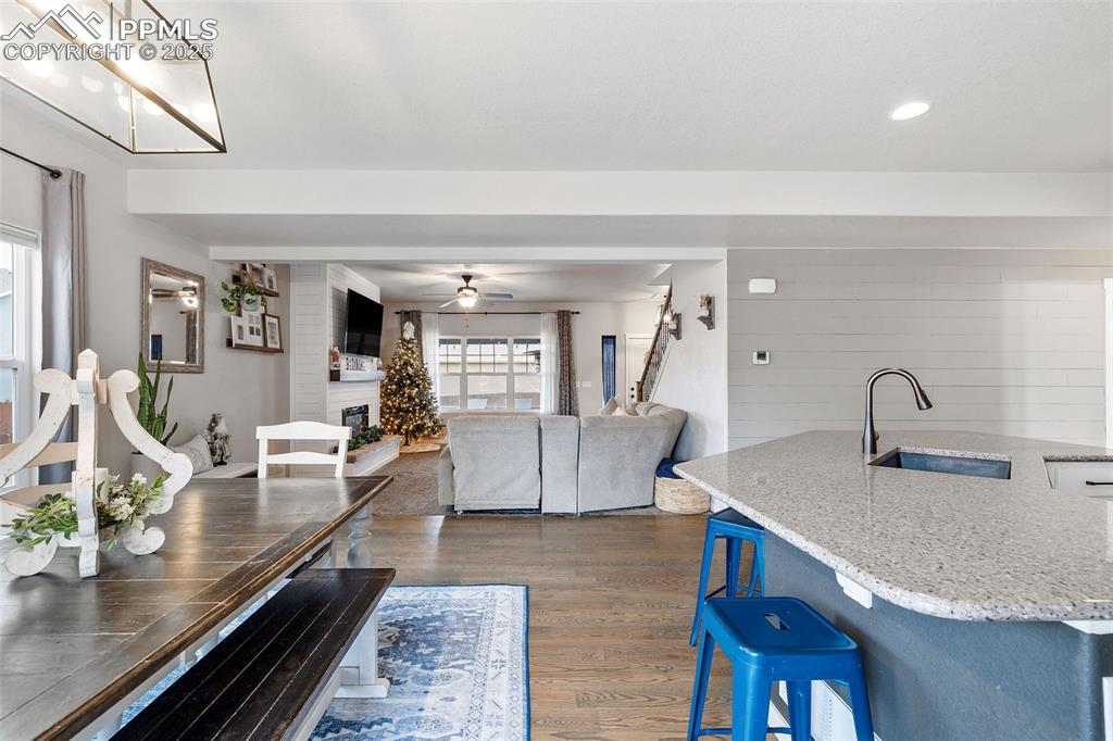 Image 16 of 43: Dining area featuring dark wood-style floors, a large fireplace, and a ceil