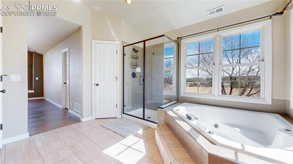 Image 22 of 50: Full bath featuring tiled floors, a whirlpool tub, a shower stall, and loft