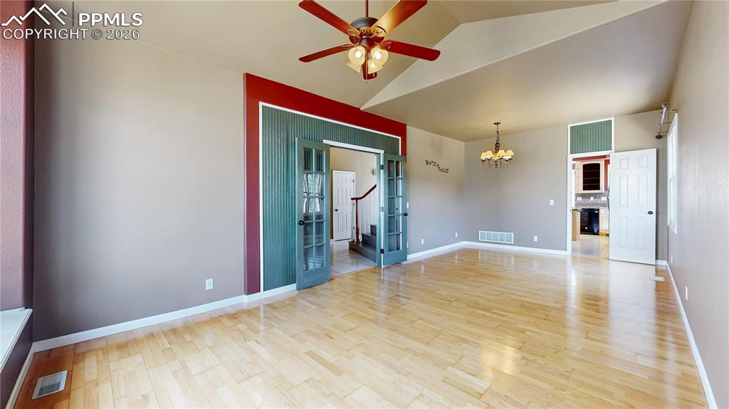 Image 43 of 50: Unfurnished room featuring suspended lighting, ceiling fan, light wood-type
