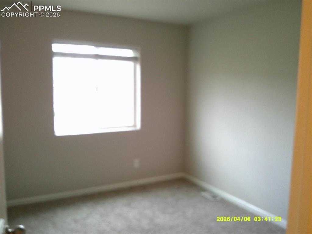 Image 10 of 13: This room features a window providing natural light, wall-to-wall carpeting