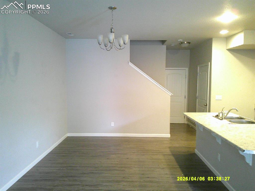 Image 2 of 13: Open concept living area with light-toned walls and wood-look flooring