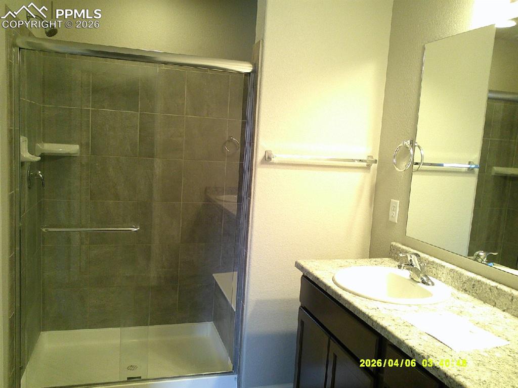Image 6 of 13: Bathroom featuring a tiled shower with a clear glass enclosure, a built-in 