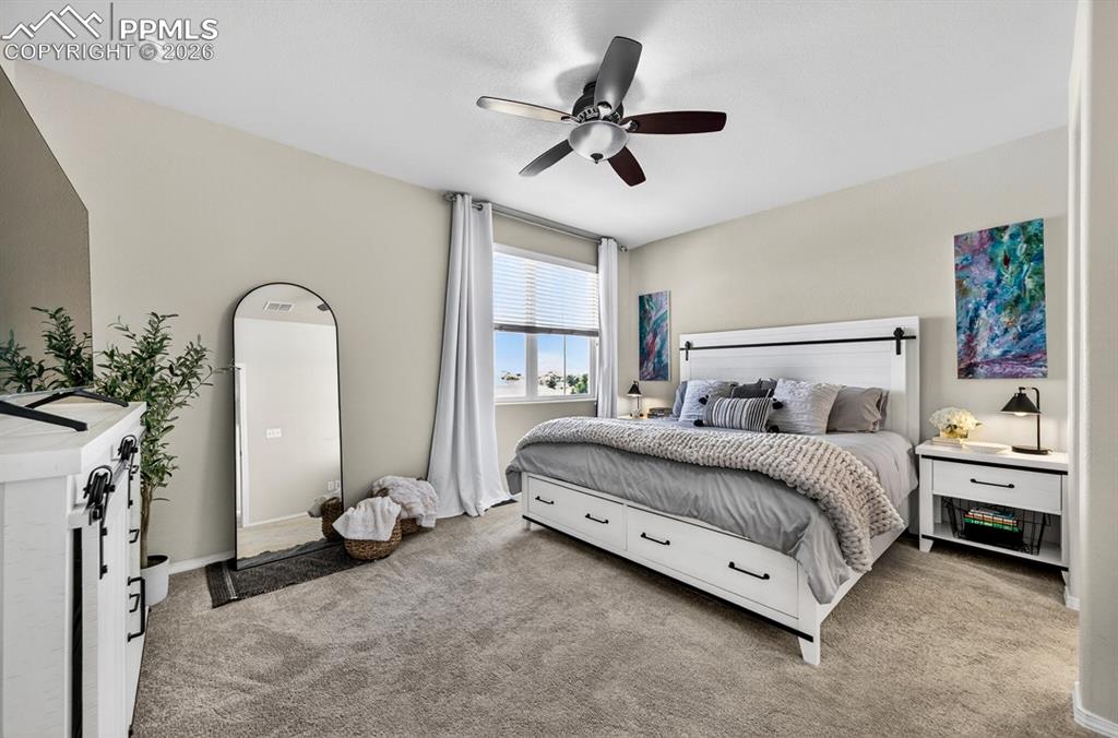 Image 23 of 42: Large, spacious primary bedroom; city view out the window